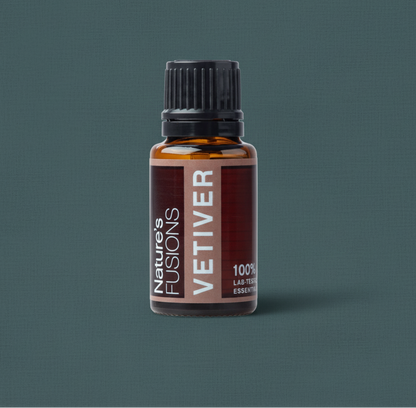 Close-up of amber glass bottle of Vetiver Essential Oil with black ribbed cap on muted teal textured background. — for Carpe Diem Dream