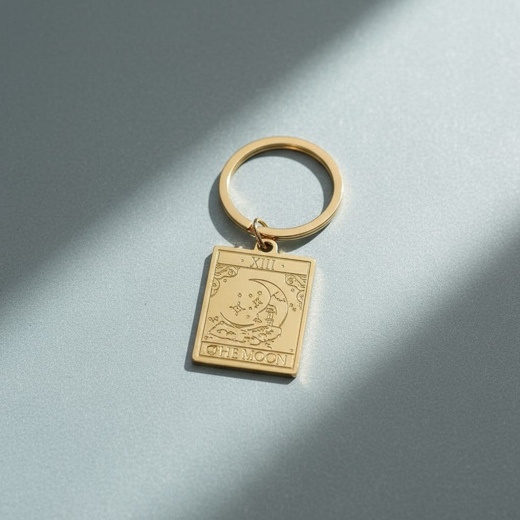 The Moon keyring from the Vintage Tarot Card Keyring collection, featuring an engraved gold moon and stars design on a soft cool-toned background, styled for Carpe Diem Dream.