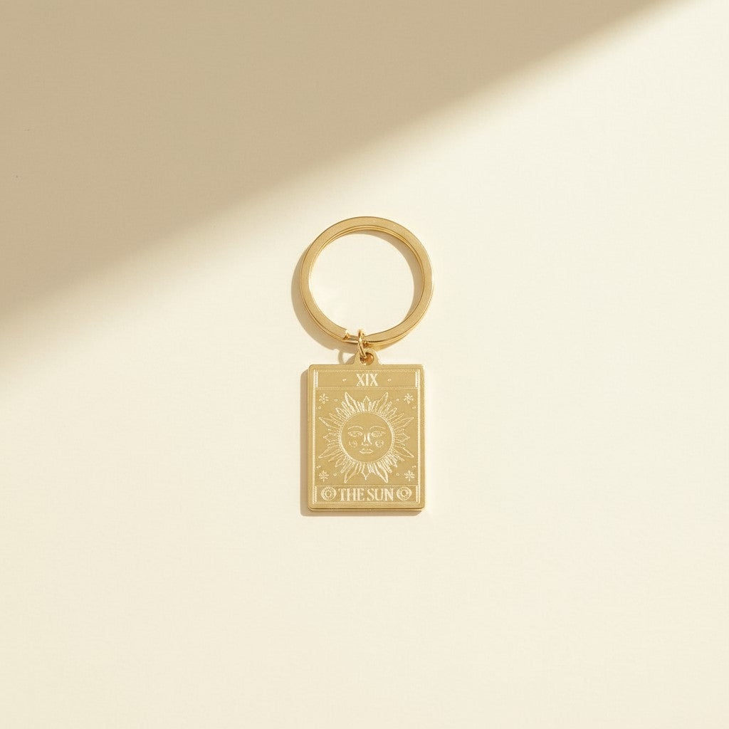 The Sun keyring from the Vintage Tarot Card Keyring collection, featuring an engraved gold design on a neutral background, styled for Carpe Diem Dream.