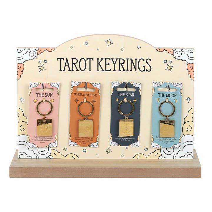 Display of four Vintage Tarot Card Keyrings — The Sun, The Wheel of Fortune, The Star, and The Moon — shown on pastel tarot packaging with engraved gold designs and a decorative retail stand, styled for Carpe Diem Dream.