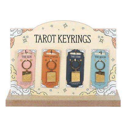 Display of four Vintage Tarot Card Keyrings — The Sun, The Wheel of Fortune, The Star, and The Moon — shown on pastel tarot packaging with engraved gold designs and a decorative retail stand, styled for Carpe Diem Dream.