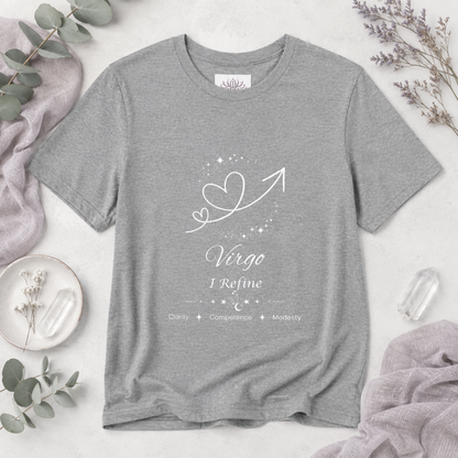 Virgo Rising I Refine zodiac T-shirt in Athletic Heather with white celestial heart and arrow artwork and Clarity, Competence, Modesty text, styled in a cool-toned studio botanical flat lay. — for Carpe Diem Dream