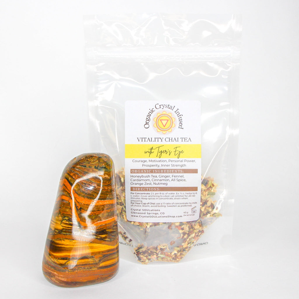 Vitality Chai Tea – Organic Crystal-Infused Tea with Tiger's Eye, 40 g clear pouch displaying the loose herbal chai blend beside a polished Tiger's Eye crystal on a clean white background — for Carpe Diem Dream