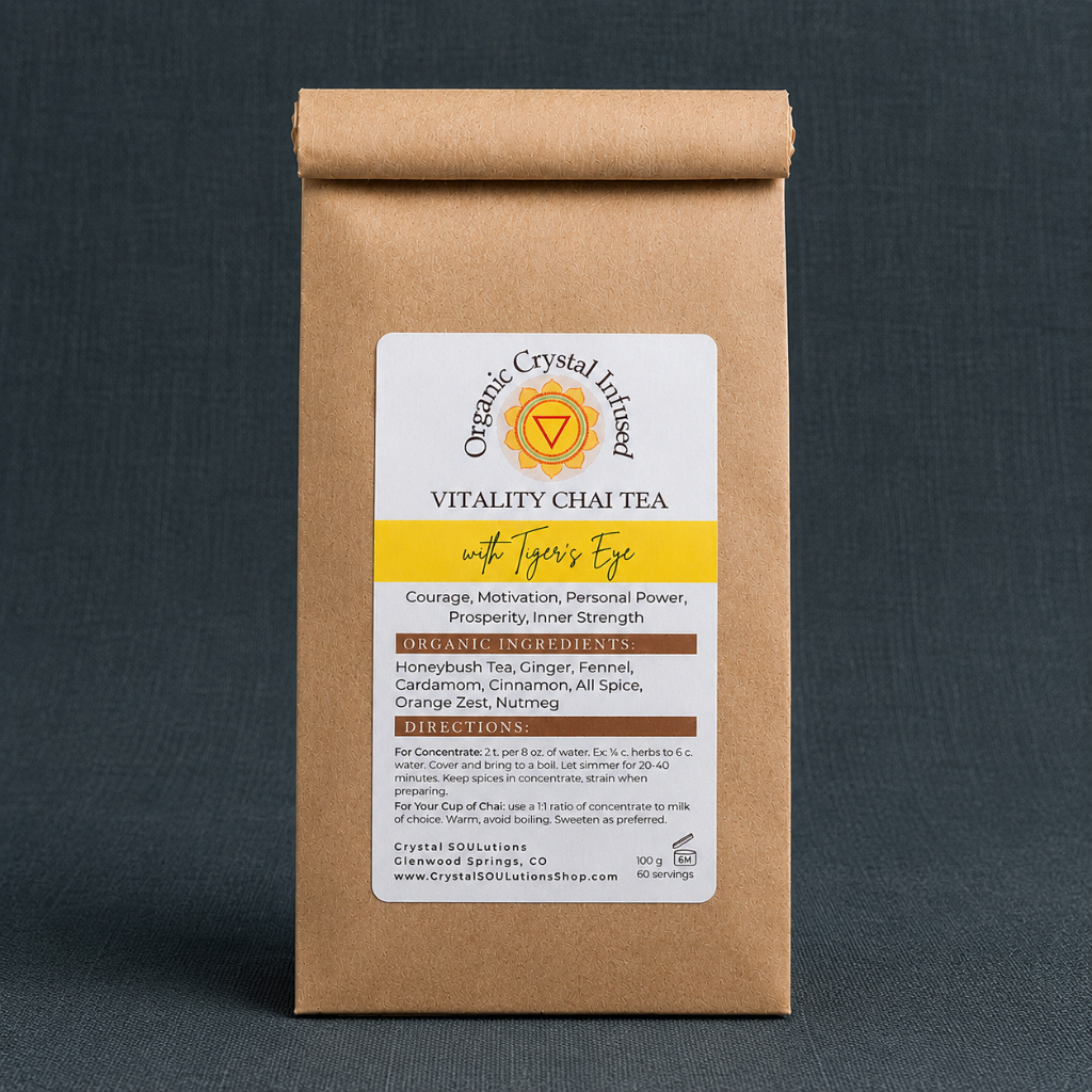 Close-up of Vitality Chai Tea – Organic Crystal-Infused Tea with Tiger's Eye highlighting the authentic 100 g kraft paper package, natural label texture, and premium packaging details in cool diffused daylight with soft shadows against Carpe Diem Dream's signature #374F59 textured linen backdrop — Carpe Diem Dream