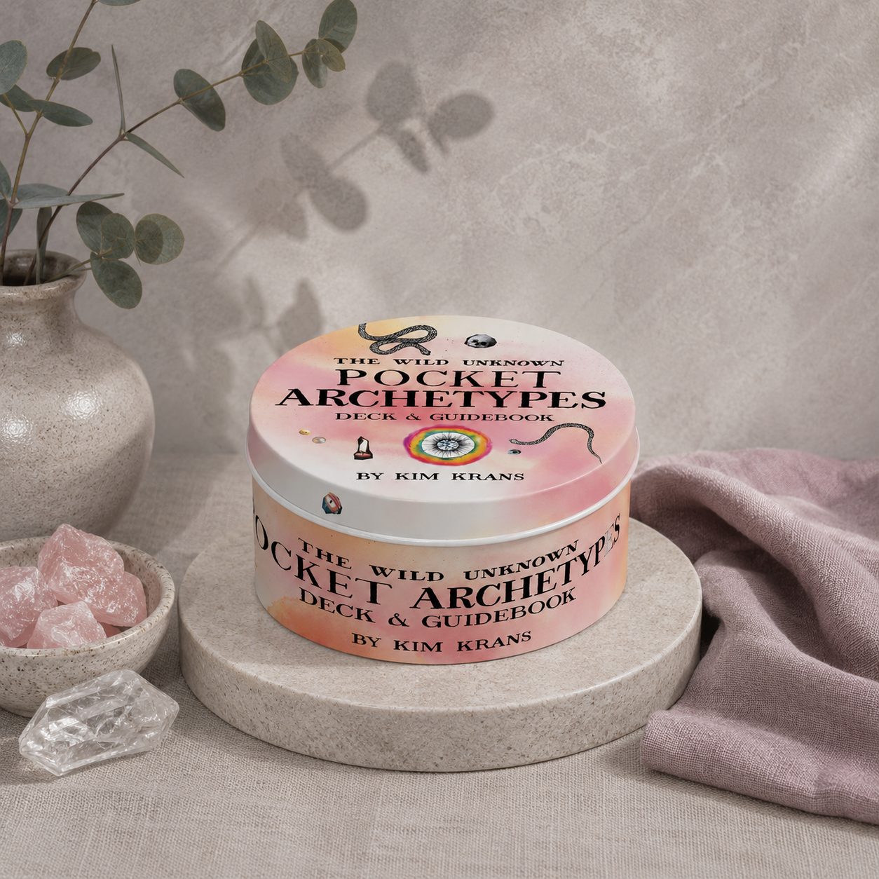 The Wild Unknown Pocket Archetypes Deck & Guidebook by Kim Krans displayed on a stone riser in the Carpe Diem Dream studio botanical setting with eucalyptus, rose quartz, cool diffused daylight, and soft botanical shadow. — for Carpe Diem Dream