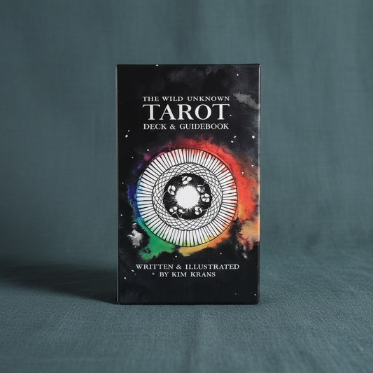 The Wild Unknown Tarot Deck box by Kim Krans displayed upright on a muted teal linen surface with soft studio lighting and a clean, minimal background. — for Carpe Diem Dream