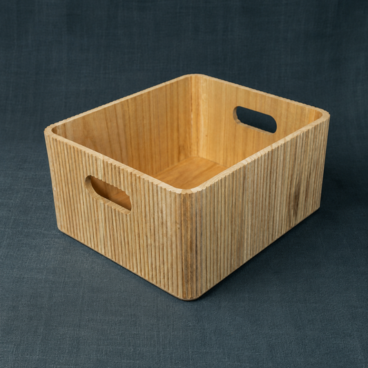 Natural wooden ribbed storage bin with rounded edges and cutout handles on a dark teal textured linen backdrop. — Carpe Diem Dream