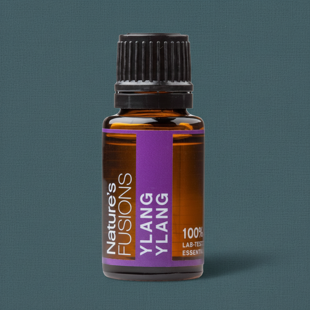 Close-up view of a 15ml amber glass bottle of Ylang Ylang essential oil with a black ribbed cap and purple label against a muted teal linen-textured background. — for Carpe Diem Dream