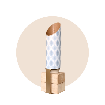 Light blue and white patterned yoga storage tube with a gold stand and wooden yoga blocks displayed on a beige circular background. — for Carpe Diem Dream