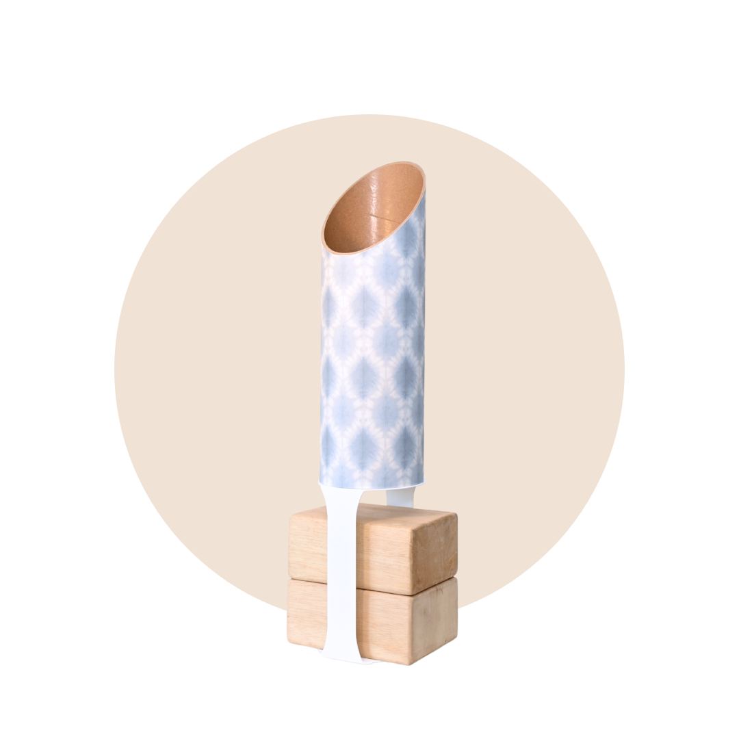 Light blue and white patterned yoga storage tube with a white stand and wooden yoga blocks displayed on a beige circular background. — for Carpe Diem Dream