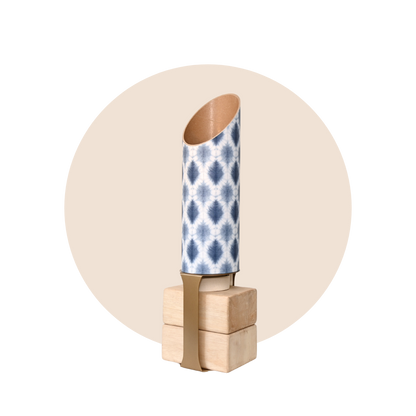 Navy and white patterned yoga storage tube with a gold stand and wooden yoga blocks displayed on a beige circular background. — for Carpe Diem Dream