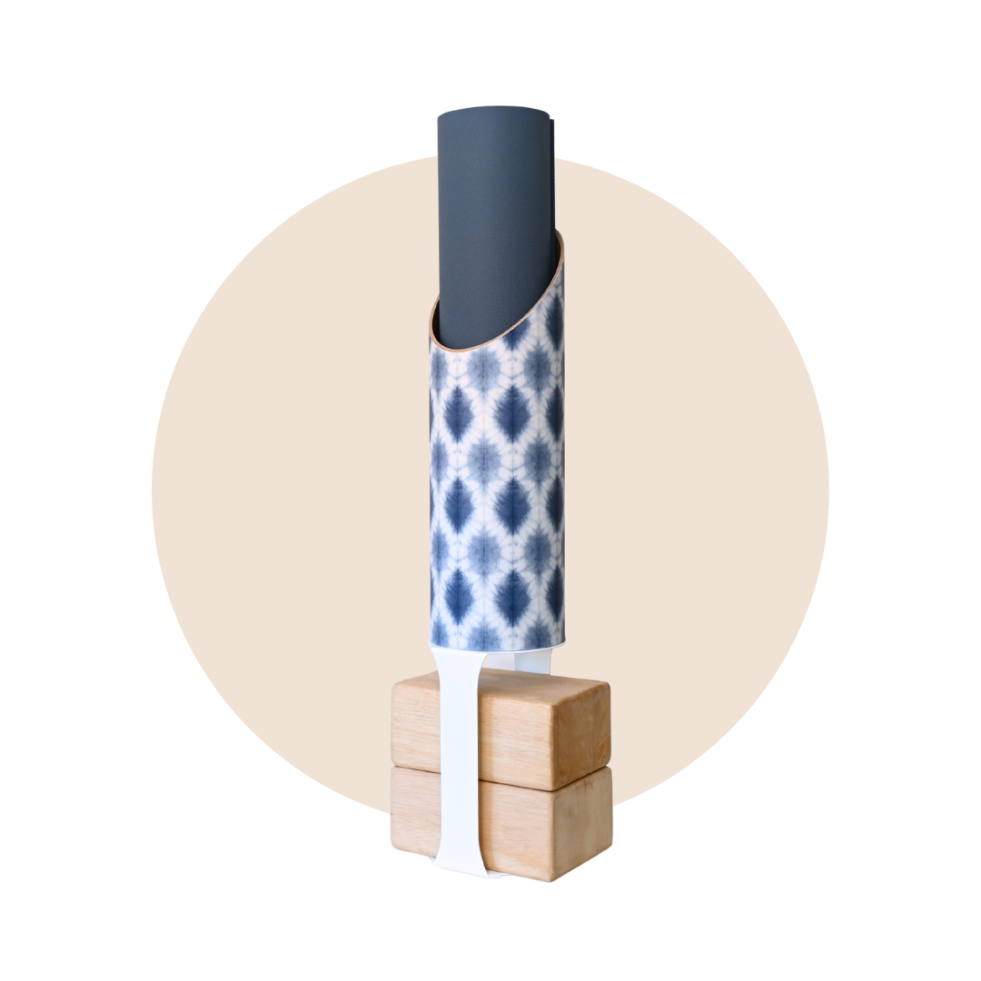Navy and white patterned yoga storage tube with a white stand and wooden yoga blocks displayed on a beige circular background. — for Carpe Diem Dream