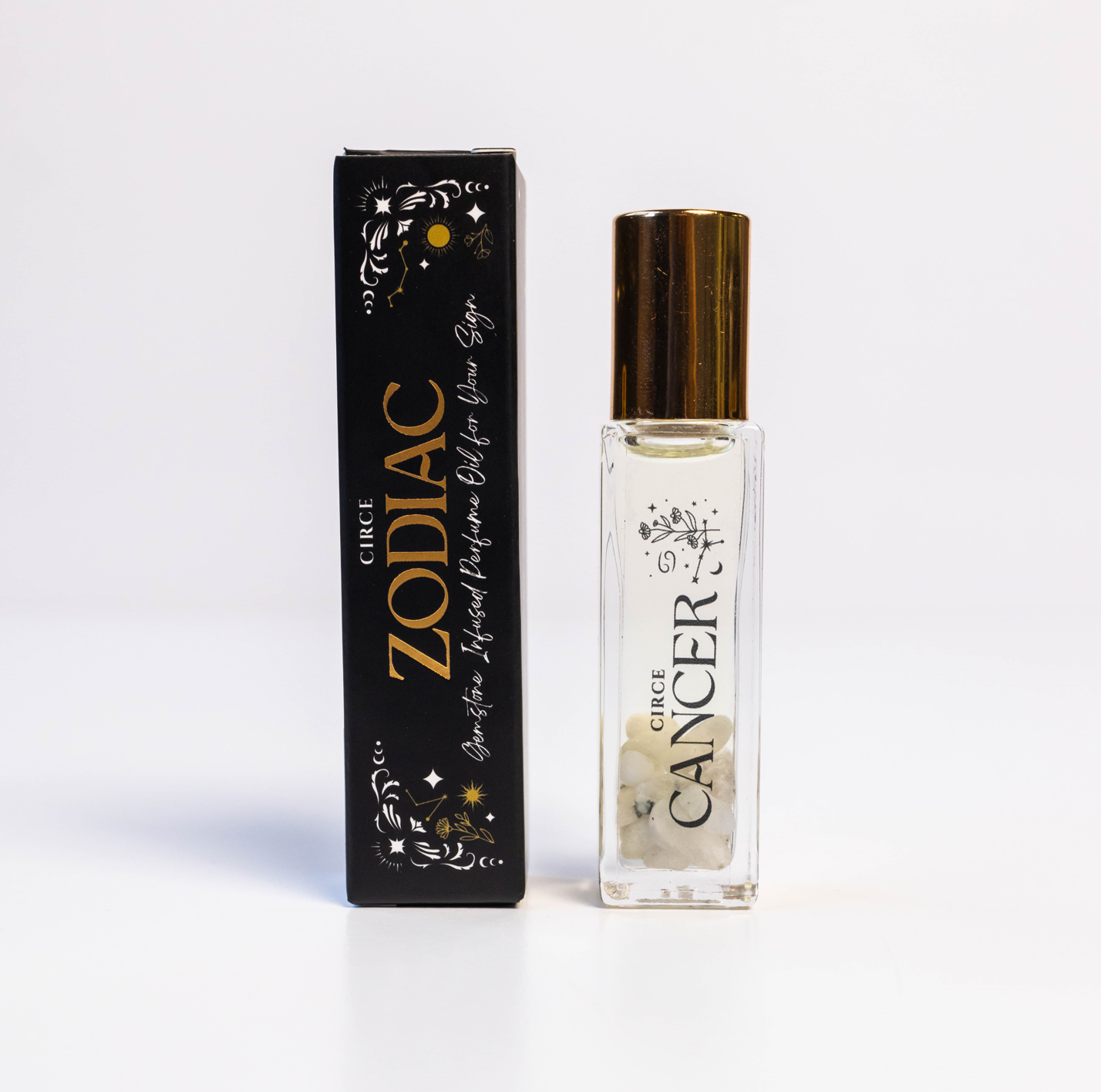 Cancer zodiac gemstone perfume oil rollerball with moonstone crystals displayed beside zodiac packaging on a white background. — for Carpe Diem Dream