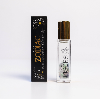 Pisces zodiac gemstone perfume oil rollerball with fluorite crystals displayed beside zodiac packaging on a white background. — for Carpe Diem Dream