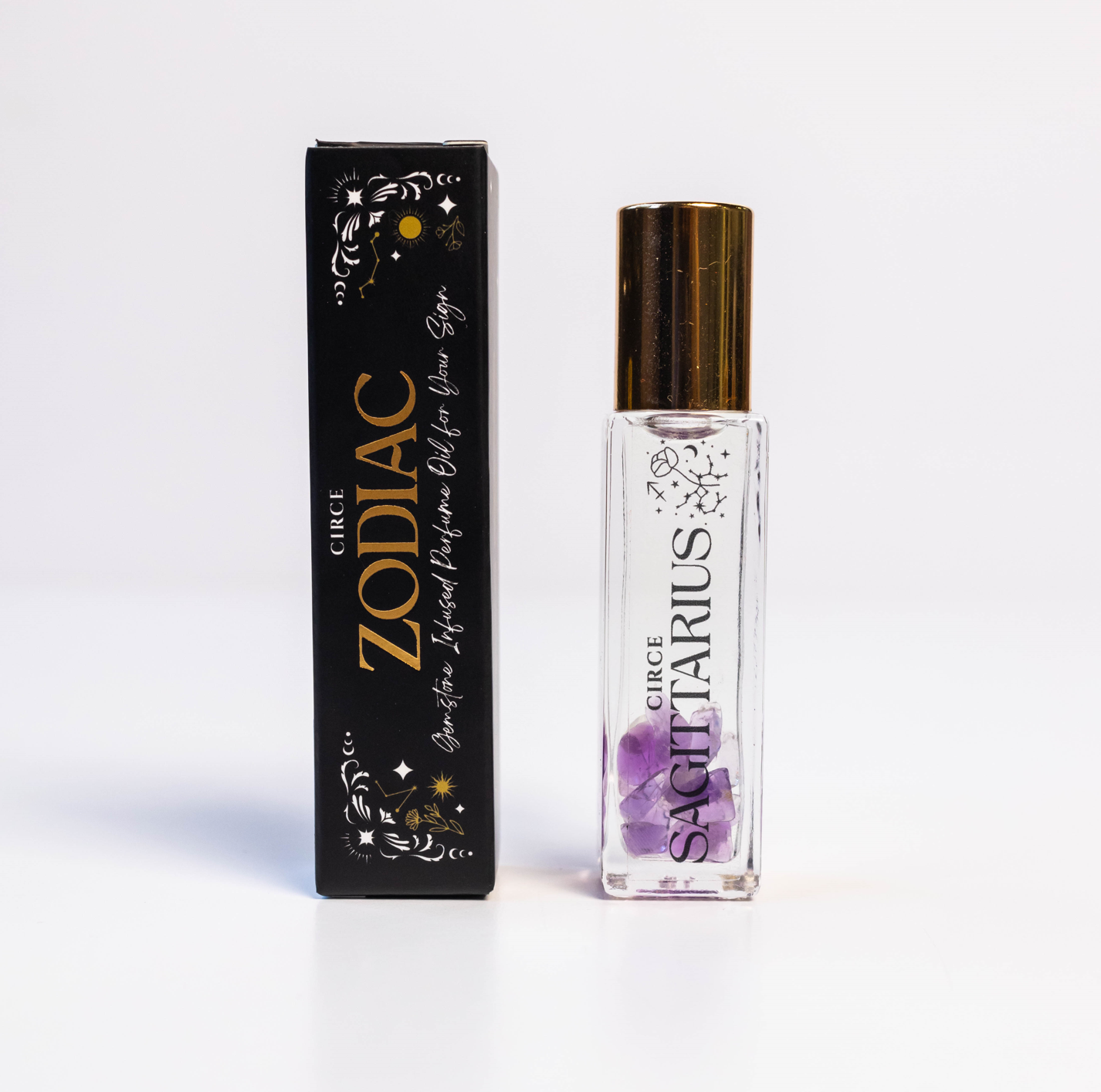 Sagittarius zodiac gemstone perfume oil rollerball with amethyst crystals displayed beside zodiac packaging on a white background. — for Carpe Diem Dream