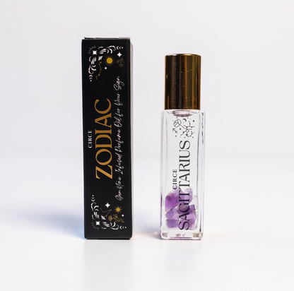 Sagittarius zodiac gemstone perfume oil rollerball with amethyst crystals displayed beside zodiac packaging on a white background. — for Carpe Diem Dream