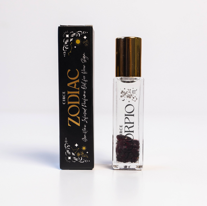 Scorpio zodiac gemstone perfume oil rollerball with garnet crystals displayed beside zodiac packaging on a white background. — for Carpe Diem Dream