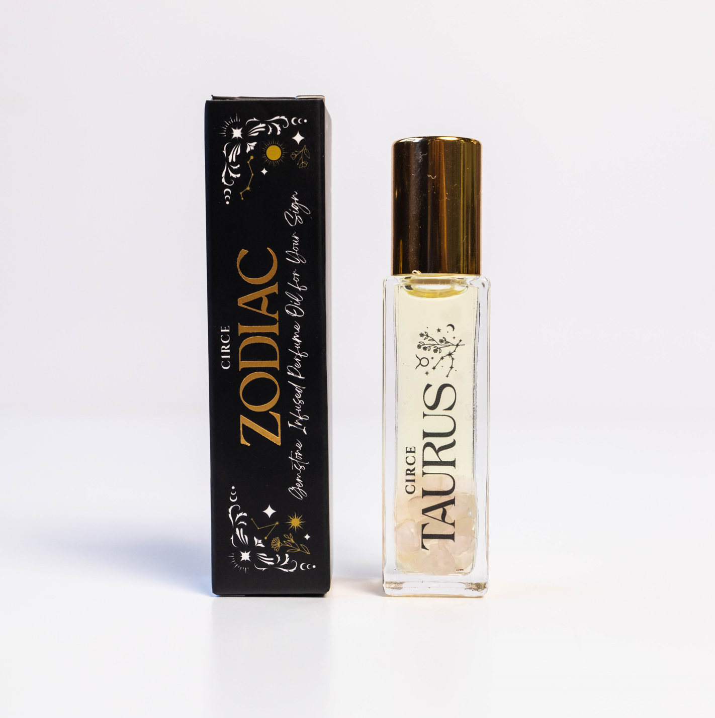 Taurus zodiac gemstone perfume oil rollerball with rose quartz crystals displayed beside zodiac packaging on a white background. — for Carpe Diem Dream
